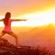 Yoga woman meditating at sunset in Grand Canyon. Female model meditating in serene harmony in warrior pose. Healthy wellness lifestyle image with multicultural young woman. From Grand Canyon, USA