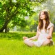 Young woman doing yoga in spring park